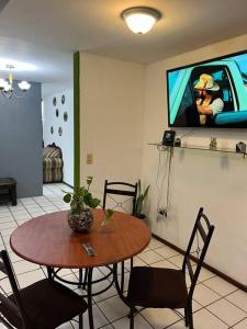 乌鲁阿潘Caza en zona residencial的一间设有桌子和墙上电视的房间