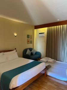 莫阿尔博阿Rufana Suites的配有一张床和一把椅子的酒店客房