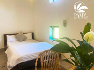 Phu YenPAMY Homestay Phú Yên的一间卧室配有一张床和盆栽植物