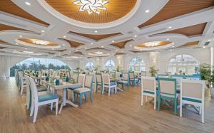 岘港Paracel Beach Hotel的用餐室设有桌椅和窗户。