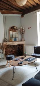 布雷斯地区布尔格La Maison du Bonheur的客厅配有咖啡桌和壁炉
