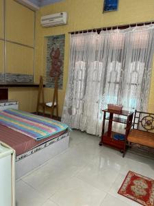 美奈San Vuon Guesthouse的一间卧室配有一张床、一张桌子和一个窗户。