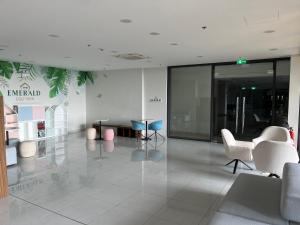 顺安The Emerald Golf View Apartment的大楼里一个空的大厅,里面摆放着桌椅