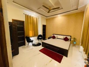 勒克瑙Atulyam Stays Sushant Golf City的一间卧室,卧室内配有一张床和椅子