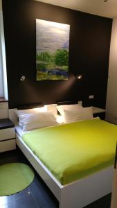 美因河畔霍海姆海姆缅因公寓的卧室配有一张绿色的床,墙上挂有绘画作品