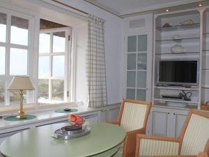 兰图姆Haus Hoppel - FeWo ground floor的厨房配有桌椅和电视。