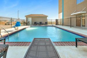 圣安东尼奥Holiday Inn Express - San Antonio East I-10 , an IHG Hotel的一座带椅子的建筑和一座大楼内的游泳池