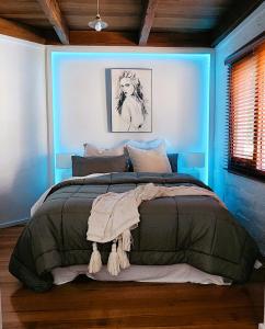 戴尔斯福特Daylesford - FROG HOLLOW ESTATE - The Homestead的一间蓝色客房内配有一张大床的卧室