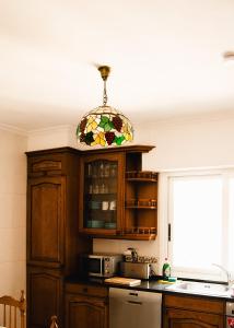 阿斯佩蒂亚Zuhaitz的厨房设有窗户和彩色玻璃吊灯。