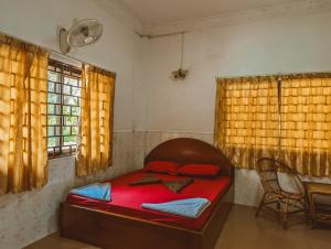贡布Yellow Star Hostel的一间卧室配有一张床、一把椅子和窗户。