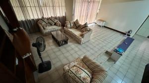 宾南邦Singa angsa house 狮鵝坊 半独立式别墅的客厅配有两张沙发和一个风扇