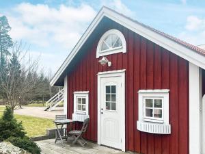 韦克舍Holiday home VÄXJÖ II的红色的房子,有白色的门和桌子
