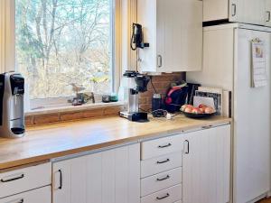 易克略Holiday home EKERÖ的厨房配有白色橱柜和带窗户的柜台。