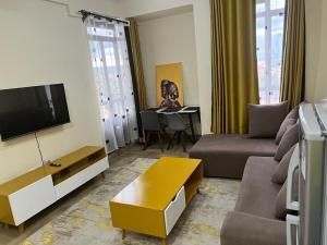 纳库鲁SuperhostHomes AirBnbs Nakuru的带沙发和电视的客厅