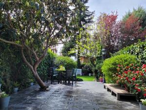 塞尔塞迪利亚La Casa Bonita Cercedilla的一个带椅子和桌子的花园以及一棵树