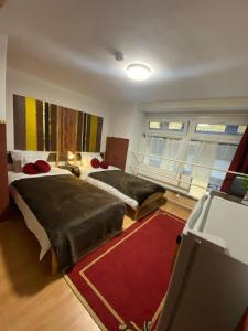 布达佩斯Allaga House的一间带两张床的卧室和红色地毯