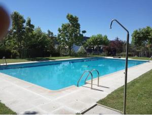 塞尔塞迪利亚La Casa Bonita Cercedilla的庭院里的一个蓝色海水游泳池