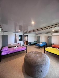 TeahupooHavae Lodge的一间设有四张床和一张搁脚凳的房间