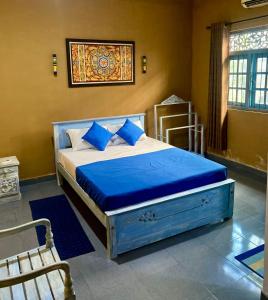 MalabeDhee Ayurved Resort Hospital的一间卧室配有一张带蓝色床单的床和一扇窗户。