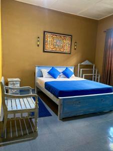 MalabeDhee Ayurved Resort Hospital的一间卧室配有一张带蓝色床单的床和一张长凳