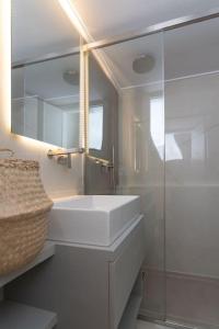 雅典LuxLoom Athens next to Hilton的白色的浴室设有水槽和玻璃淋浴间。