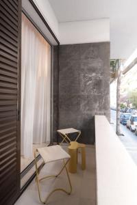 雅典LuxLoom Athens next to Hilton的阳台配有椅子、桌子和窗户。