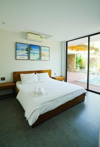 富国Kiwuki Beachfront Villa的一间卧室配有一张大床和两条毛巾