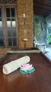 MalabeDhee Ayurved Resort Hospital的桌上的毛巾和花