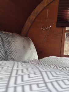 勒沃库森Für Alleinreisende-1 Person- Single Room- Rustikales freistehendes Mini Holzfass zum Schlafen, mit angrenzendem Badezimmer!的木墙上有心标的床