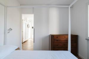 塞勒里古ABC affittacamere的卧室配有白色的床和木制梳妆台。