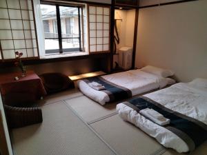 京都秋桜館Cosmos的带窗户的客房内的两张床