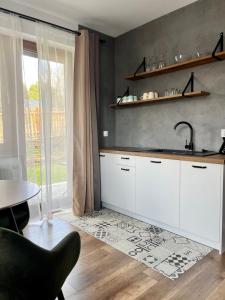 韦特利纳Donikąd的厨房配有白色橱柜、水槽和桌子