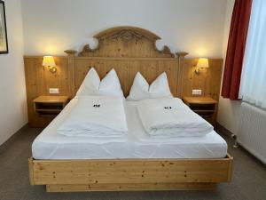 特翁Landhotel Postgut - Tradition seit 1549的一间卧室配有带白色床单和枕头的床。