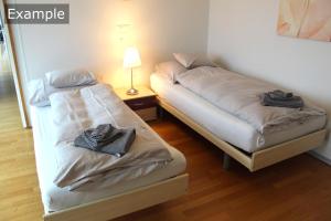 伯尔尼塞恩尼韦塔西城公寓的客房内的两张床和毛巾