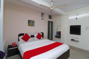 普里Goroomgo Padoshi Near Sea Beach Puri - Spacious Room 100 Meters From Sea Beach的一间卧室配有一张带红色枕头的大床