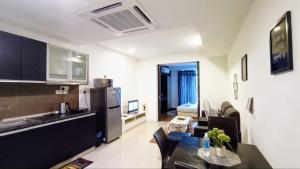 吉隆坡Taragon Apartment - KL的厨房以及带沙发和桌子的客厅。