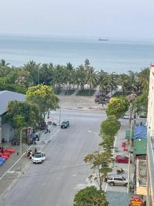 格卢市社Khách sạn Sơn Hiền Cửa Lò的享有棕榈树街道和大海的空中景致