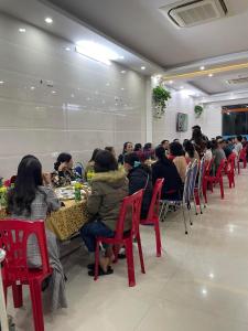 格卢市社Khách sạn Sơn Hiền Cửa Lò的一群坐在房间里桌子的人