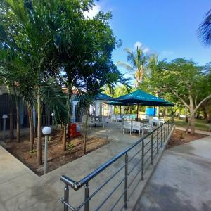 蒙巴萨Maasai Barracks Resort的餐厅设有桌子、遮阳伞和棕榈树。