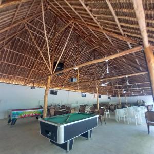 蒙巴萨Maasai Barracks Resort的大型客房配有台球桌和椅子