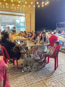 格卢市社Khách sạn Sơn Hiền Cửa Lò的一群坐在餐厅桌子上的人