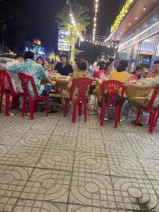 格卢市社Khách sạn Sơn Hiền Cửa Lò的一群人晚上坐在餐馆的桌子上