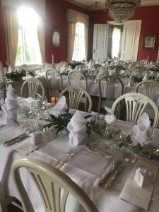 Moholm莫尔勒斯庄园酒店的用餐室配有白色的桌子和白色的椅子