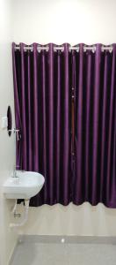 钦奈SR RESIDENCY的紫色的淋浴帘,浴室内有水槽