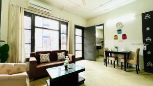 古尔冈Olive Service Apartments - Medanta Medicity的客厅配有沙发和桌子