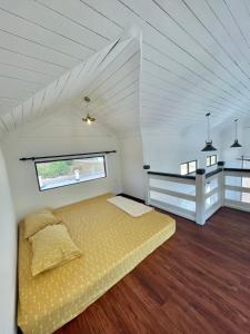 士兆Tiny House & Pool 4 pax 3 mins Merang Jetty的一间白色客房内的黄色床卧室