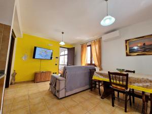 利帕里Rosa's house的客厅配有桌子和黄色墙壁