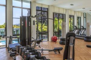 拉威海滩Luxury King Bed Apartment with Pool View and Sauna的健身房设有许多健身器材和窗户