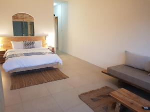 格兰贝伊Villas Rocher - Junior Suite 2C的一间卧室配有一张床和一张沙发