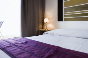 塞拉迪费罗R sidence Alba Rossa Serra di Ferro accommodation with terrace or balcony的卧室配有紫色和白色的床和窗户。